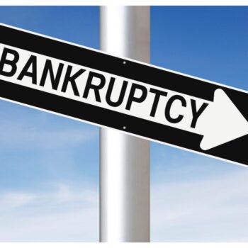 Znak drogowy - biała strzałka na czarnym tle z napisem Bankruptcy -upadłość